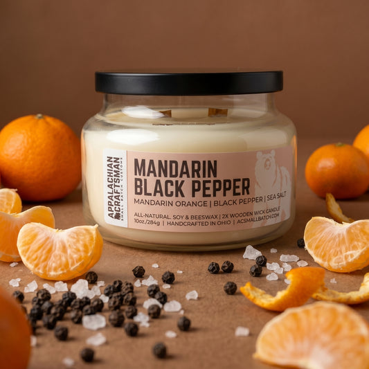 Candle jar labeled 'Mandarin Black Pepper' with mandarin oranges and black peppercorns on a brown background