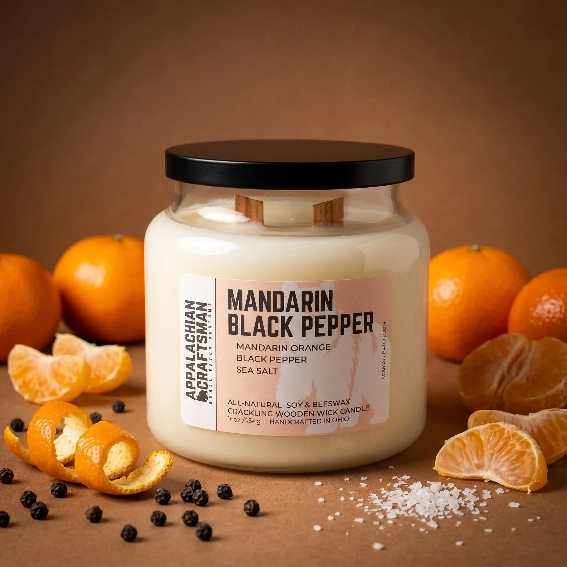 Candle jar labeled 'Mandarin Black Pepper' with mandarin oranges and black peppercorns on a brown background