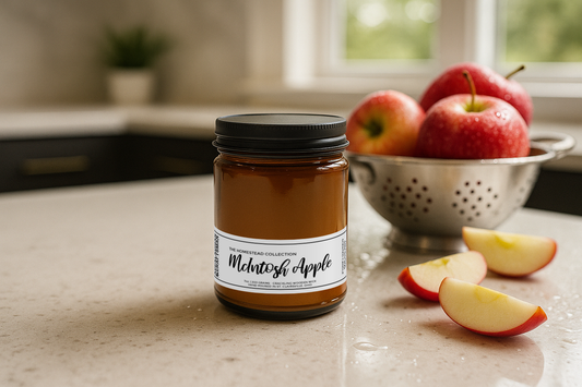 McIntosh Apple scented glass jar candle on a kitchen counter with apples in the background