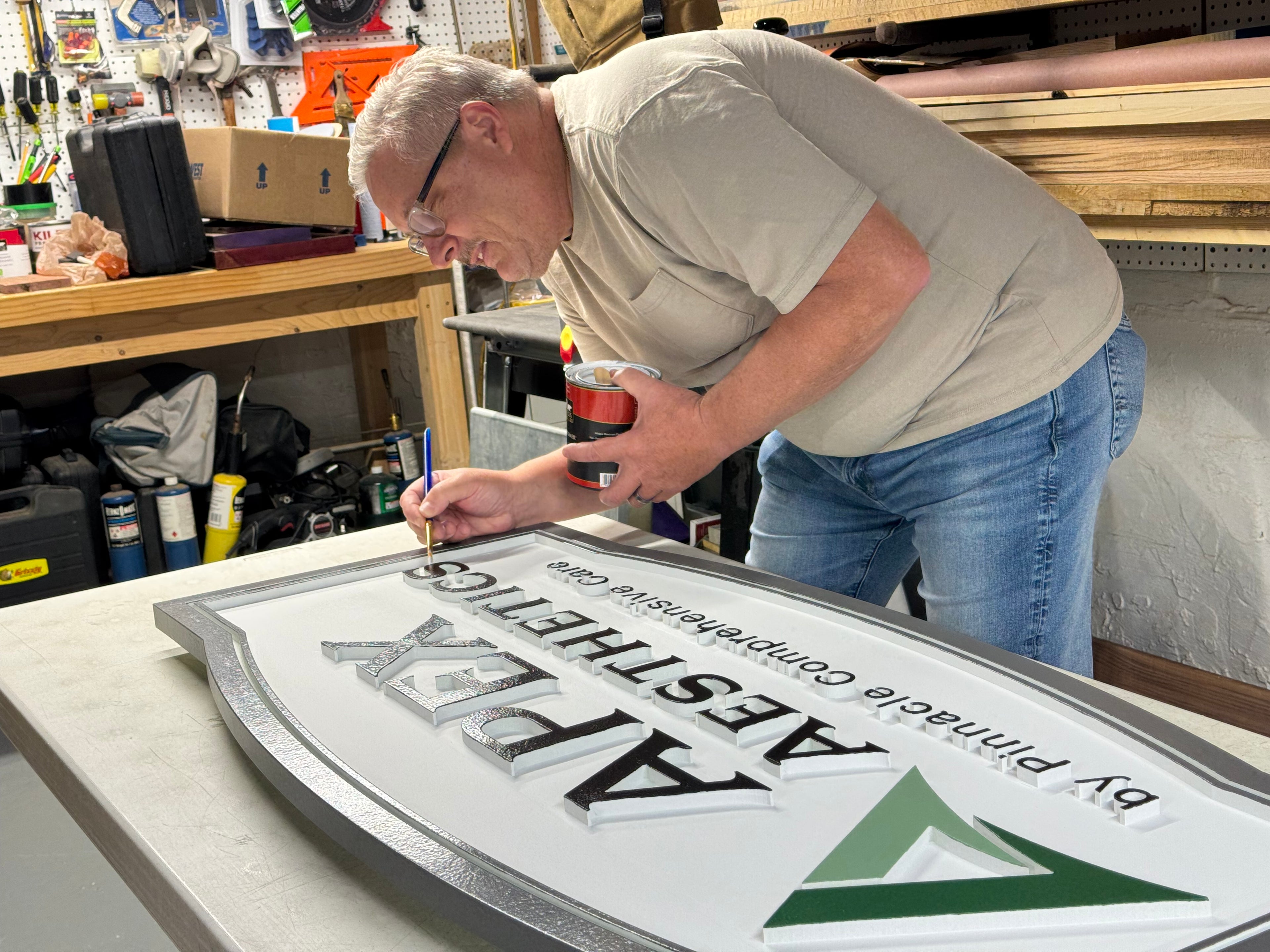 image of man painting sign by hand